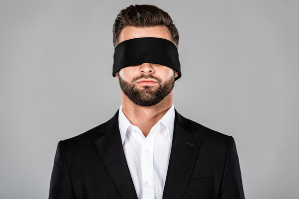 bearded handsome blindfolded businessman in black suit isolated on grey - Foto, Bild