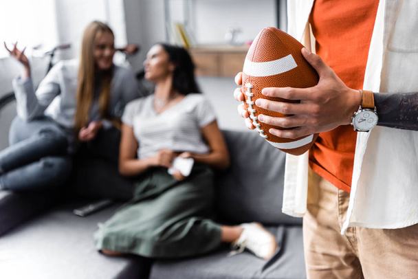 selective focus of man holding Rugby Ball in apartment  - Photo, Image