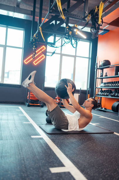 Nice good looking man training alone in the gym - Foto, Bild