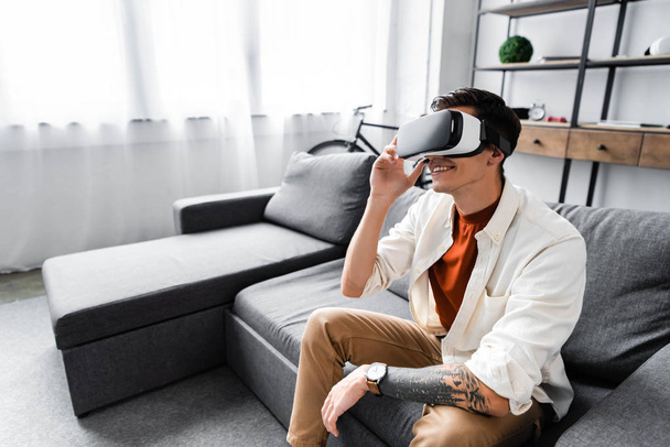 emotional man in shirt with virtual reality headset in apartment  - Photo, Image