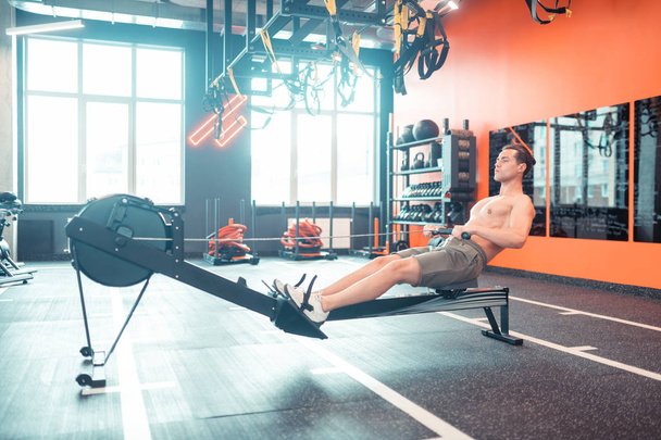 Handsome fit man exercising alone in the gym - Photo, image