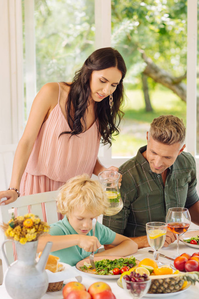 Prendre soin de maman regarder son fils manger dans la maison d'été
 - Photo, image