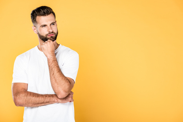 thoughtful handsome man in white t-shirt isolated on yellow with copy space - Φωτογραφία, εικόνα