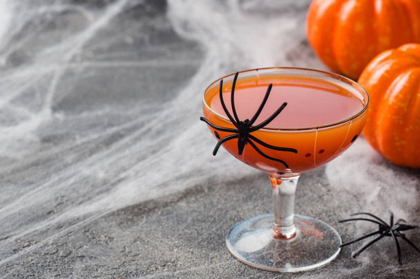 frischer Kürbissaft. Konzept Halloween-Feier. Hintergrund des Spinnennetzes. - Foto, Bild