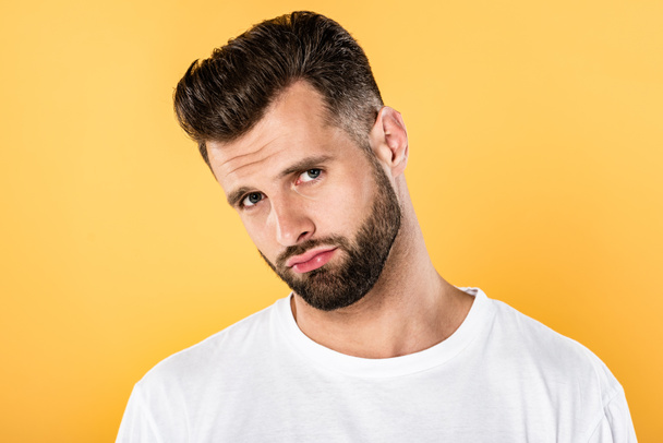 upset handsome man in white t-shirt isolated on yellow - Foto, immagini