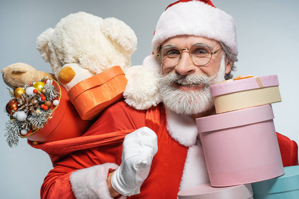 Kerstman glimlachend en houdt Sack met cadeautjes - Foto, afbeelding