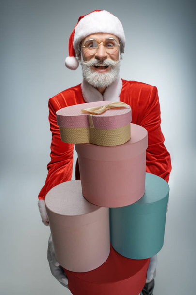 Mature Santa Claus holding gift box in hands - Fotoğraf, Görsel
