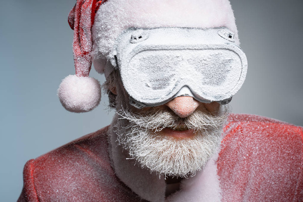 Mature aged Santa Claus in frozen protective glasses - 写真・画像