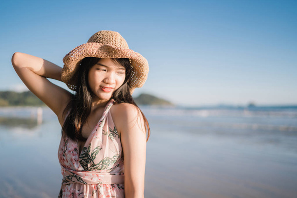 Młody Asian kobieta uczucie szczęśliwy na plaży, piękne kobiece szczęśliwy relaks uśmiechnięta zabawa na plaży w pobliżu morza, gdy zachód słońca wieczorem. Lifestyle kobiet podróży na plaży koncepcji. - Zdjęcie, obraz
