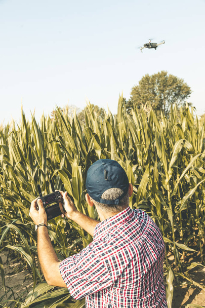 modern technological farmer analyzing the growth of corn by flyi - Φωτογραφία, εικόνα