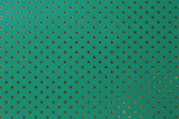 Fond vert foncé de papier d'aluminium métallique avec un motif d'étoiles dorées
. - Photo, image