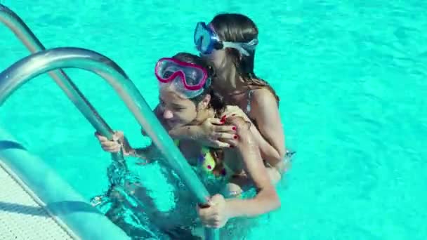 Two teen sisters having fun in pool at daytime - Filmati, video