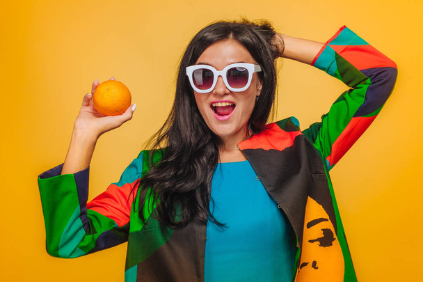 Parlak giysiler içinde güneş gözlüğü sarı arka plan üzerinde Kız - Fotoğraf, Görsel