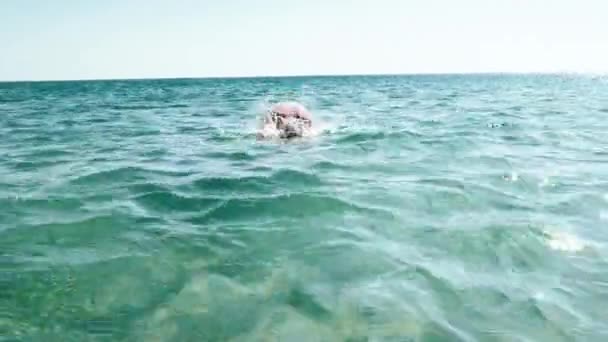 Orta yaşlı bir adam gündüz vakti denize dalıyor.  - Video, Çekim