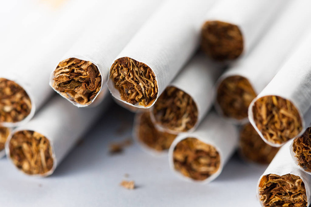 Многочисленные сигареты изолированы на белом фоне. Табак может вызвать заболевания в организме. Курение вредит твоему телу
. - Фото, изображение