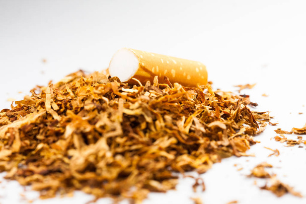 Rozdrobnione tytoń z taką dyszą na górze, izolowane na białym tle. Tytoń może wywoływać choroby w organizmie. - Zdjęcie, obraz