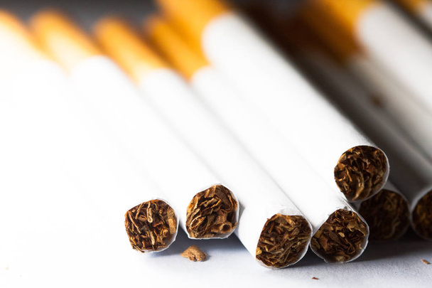 De nombreuses cigarettes isolées sur fond blanc. Le tabac peut causer des maladies dans l'organisme. Fumer fait mal à votre corps
. - Photo, image
