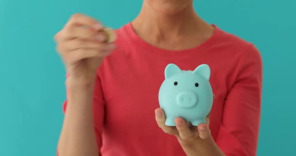 Mujer positiva poniendo moneda en la hucha, presupuesto de planificación, ahorros financieros
 - Imágenes, Vídeo