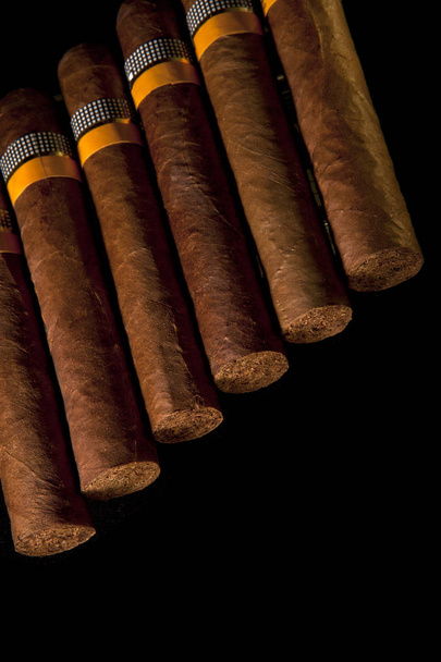 rolled cigars from a tobacco leaf on a black background, Small depth of sharpnes - Foto, imagen