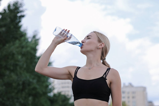 Nuori urheilullinen nainen juo vettä pullosta. Kunto- ja elämäntapakonsepti
 - Valokuva, kuva