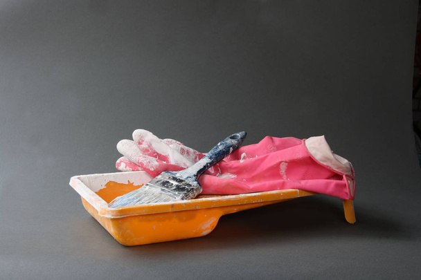 Yellow paint pot, blue brush and red gloves - 写真・画像