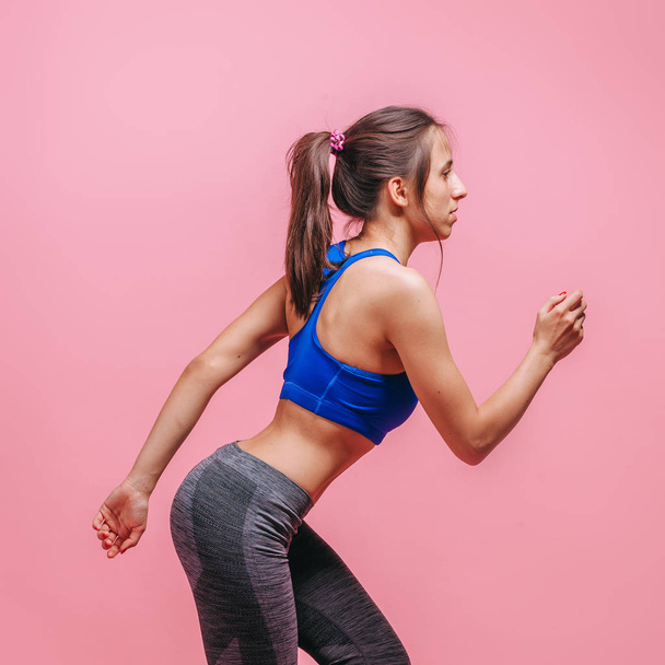 Girl doing sports on a pink background - Foto, afbeelding