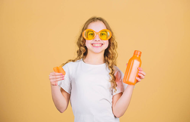 happy girl drink fresh carrot juice. summer vacation. little girl in fashion glasses. Vitamin nutrition. refreshing vitamin juice. Health. Summer vitamin diet. Natural vitamin source. Organic food - Fotografie, Obrázek
