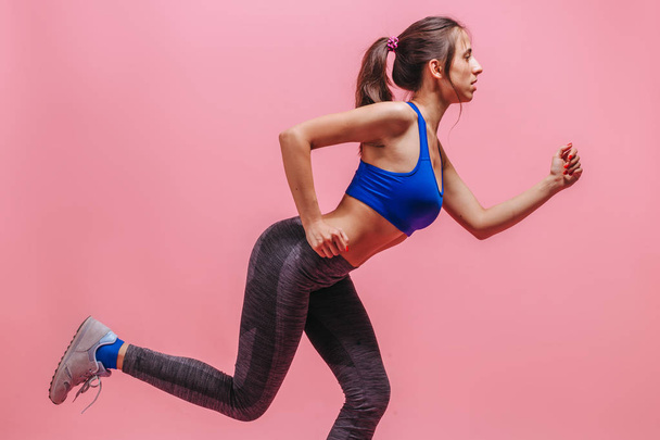 girl do exercises on a pink background - Fotó, kép