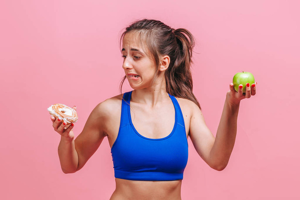 girl on a pink background holding a cake and an Apple - Fotó, kép