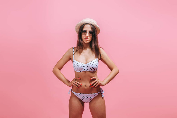 Girl in swimsuit sunglasses and hat on pink background. - Foto, imagen