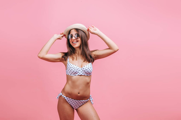 Girl in swimsuit sunglasses and hat on pink background. - Photo, Image