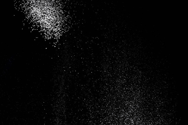 Salpicadura de polvo blanco aislado sobre fondo negro. Tamizado de harina
  - Foto, Imagen