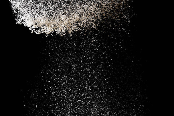 Flour sifting on a black background. White powder splash isolate - Foto, immagini