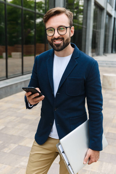 Attractive smiling young bearded man wearing jacket - Valokuva, kuva