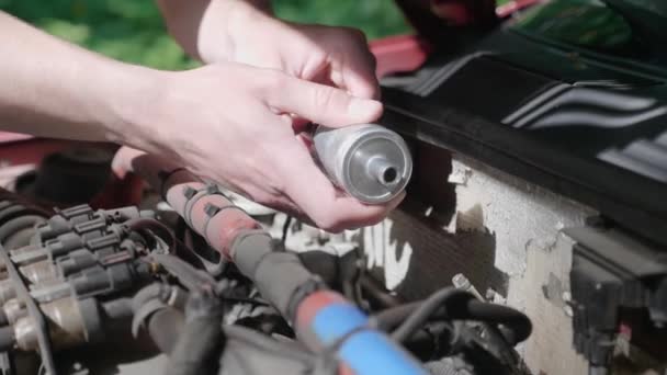 Close-up of the hands of a man who independently replaces the Lpg filter in his car. Young guy repairing auto in outdoor. The automobile broke down on the road. 4K footage. - Footage, Video