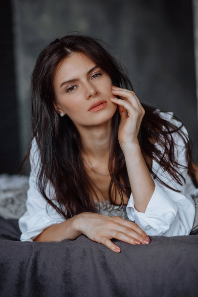 Brunette girl lying on the bed, close-up portrait - Foto, afbeelding