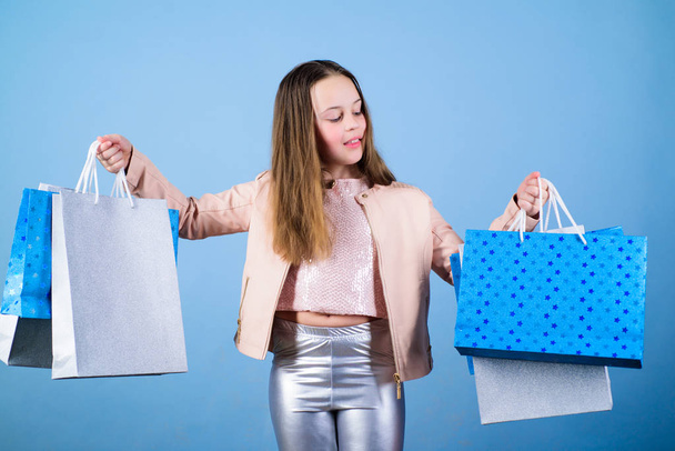 Fashion boutique. Fashion trend. Fashion shop. Little girl with bunch packages. Fashion girl customer. Happy child in shop with bags. Shopping day happiness. Buy clothes. Birthday girl shopping - Photo, image