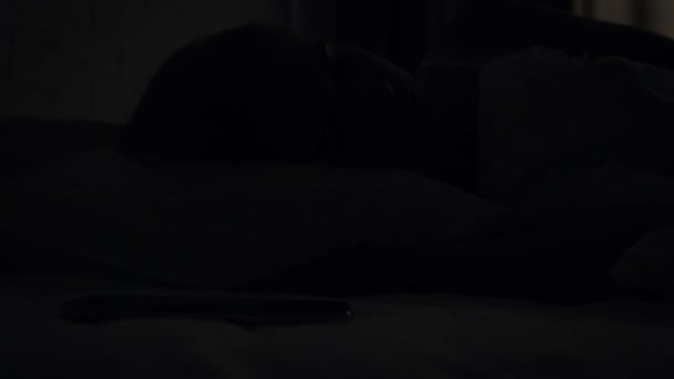 Mujer somnolienta apaga la alarma mientras se despierta por la mañana
. - Metraje, vídeo