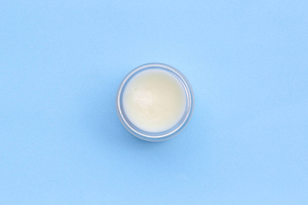 Jar cosmetic cream for face on blue background. Top view, flat lay. Medicine skincare products, modern concept of organic beauty trend. - Photo, Image
