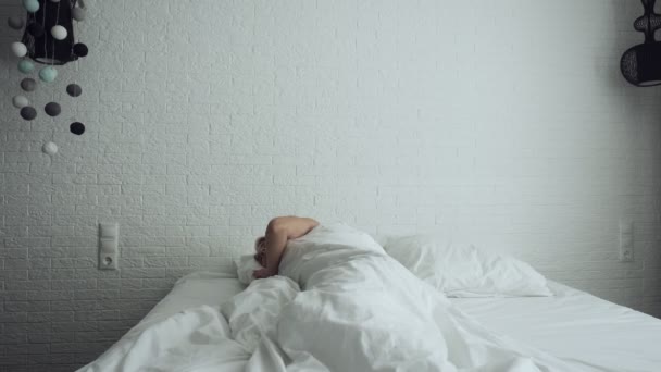 Žena probourající se v pohodlné útulné posteli roztahuje a získává. - Záběry, video