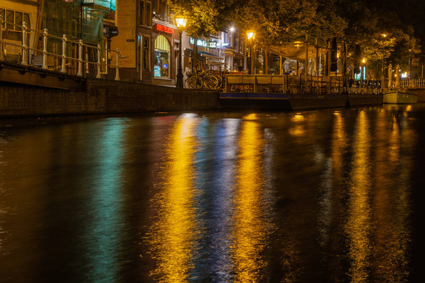 Nederlands stadscentrum met onscherpe reflecties in water - Foto, afbeelding