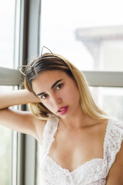 Beautiful young woman posing near window wearing lingerie - Foto, Bild