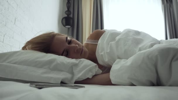 眠い女性は、朝起きている間にアラームをオフにします. - 映像、動画
