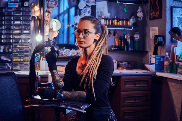 Retrato de jovem atraente com máquina de tatuagem nas mãos
 - Foto, Imagem