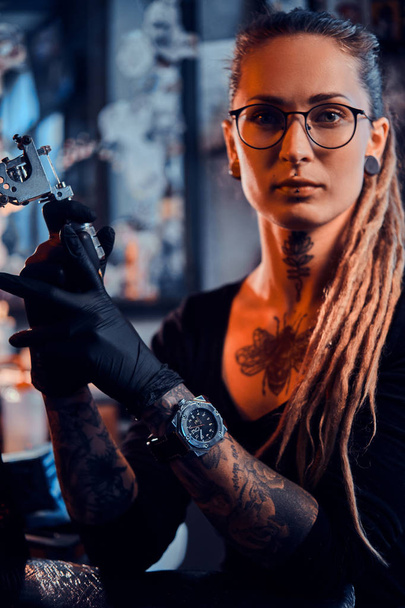 Портрет привабливої молодої жінки з татуювальною машиною в руках
 - Фото, зображення