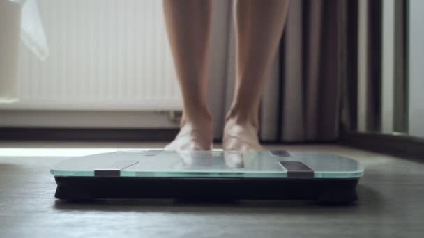 Unrecognizable woman stands on floor scale in the bedroom. - Footage, Video