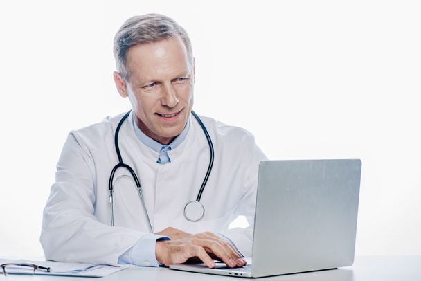 bel dottore in cappotto bianco con computer portatile isolato su bianco
  - Foto, immagini