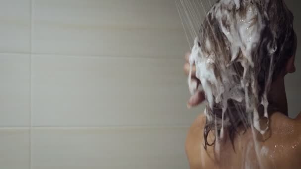 Hermosa chica lavando el cabello y disfrutar bajo la ducha
. - Metraje, vídeo