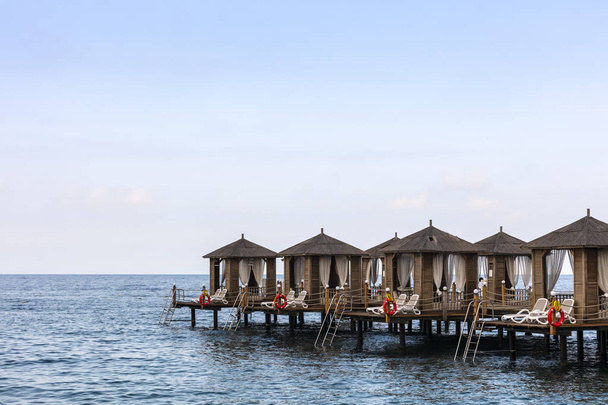 Luxusní plážové chatky na dřevěném molu v moři. - Fotografie, Obrázek