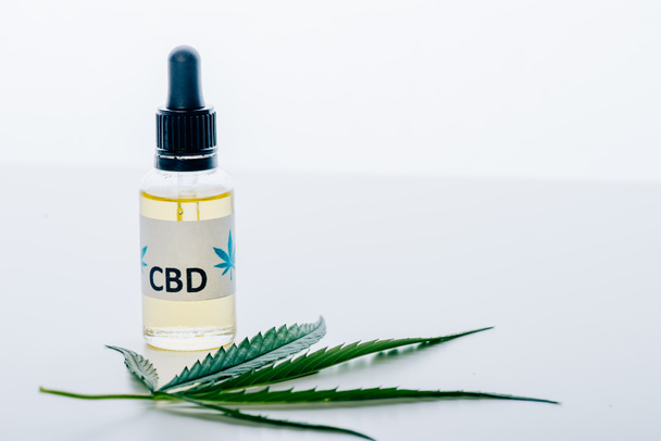 cannabis oil in bottle with lettering cbd and marijuana on white background  - Foto, Imagem